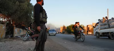 A Bedouin fighter holds a weapon as he stands along a street, as Sweida province has been engulfed by nearly a week of violence triggered by clashes between Bedouin fighters and factions from the Druze, at Sweida governorate, Syria, July 18, 2025. REUTERS/Karam al-Masri