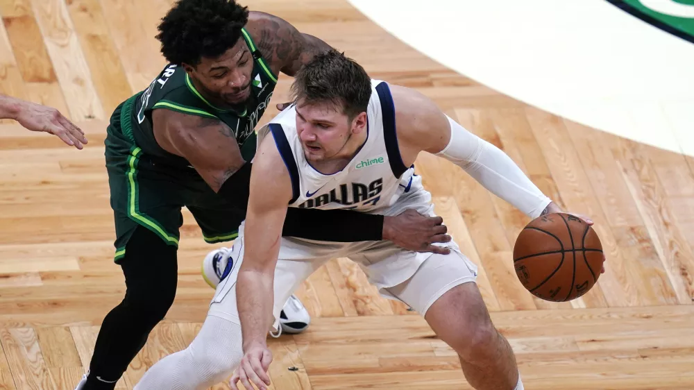 Dallas Mavericks guard Luka Doncic, right, is pressured by Boston Celtics guard Marcus Smart during the second half of an NBA basketball game Wednesday, March 31, 2021, in Boston. (AP Photo/Charles Krupa)