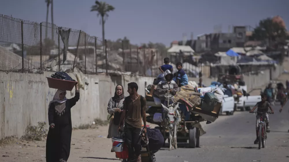 Palestinians flee Deir al-Balah in central Gaza Sunday, July 20, 2025, after the Israeli military issued evacuation orders ahead of expected operations in the area. (AP Photo/Abdel Kareem Hana)