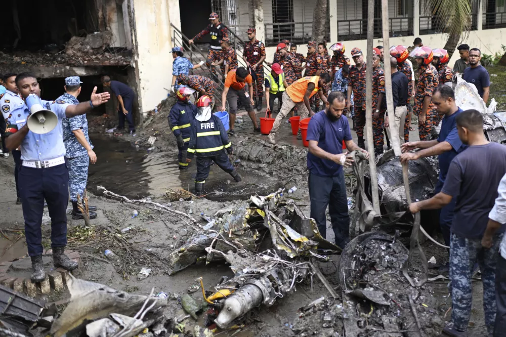 Firemen work at the site of a Bangladesh Air Force training aircraft that crashed into a school campus shortly after takeoff in Dhaka, Bangladesh, Monday, July 21, 2025. (AP Photo/Mahmud Hossain Opu)