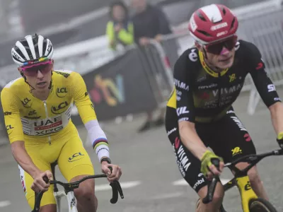 Denmark's Jonas Vingegaard, front, and Slovenia's Tadej Pogacar, wearing the overall leader's yellow jersey, ride in the final climb during the fourteenth stage of the Tour de France cycling race over 182.6 kilometers (113.5 miles) with start in Pau and finish in Luchon Superbagneres, France, Saturday, July 19, 2025. (AP Photo/Thibault Camus)