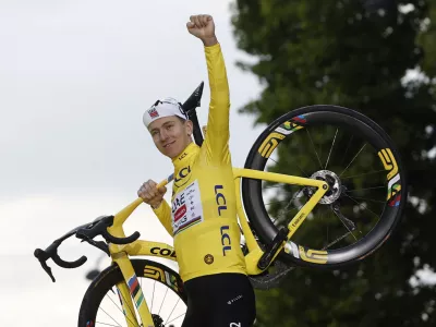 Cycling - Tour de France - Stage 21 - Mantes-la-Ville to Paris - Paris, France - July 27, 2025 UAE Team Emirates XRG's Tadej Pogacar celebrates on the podium with his bike while wearing the yellow jersey after winning the Tour de France REUTERS/Benoit Tessier