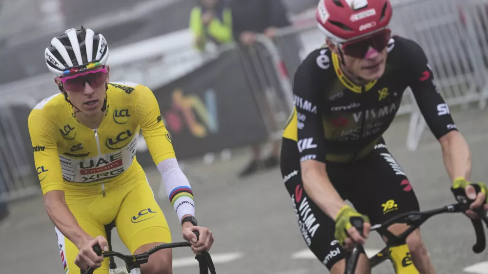 Denmark's Jonas Vingegaard, front, and Slovenia's Tadej Pogacar, wearing the overall leader's yellow jersey, ride in the final climb during the fourteenth stage of the Tour de France cycling race over 182.6 kilometers (113.5 miles) with start in Pau and finish in Luchon Superbagneres, France, Saturday, July 19, 2025. (AP Photo/Thibault Camus)