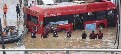 Rescuers search for survivors along a road submerged by floodwaters leading to an underground tunnel in Cheongju, South Korea, Sunday, July 16, 2023. Days of heavy rain triggered flash floods and landslides and destroyed homes, leaving scores of people dead and forcing thousands to evacuate, officials said Sunday. (Kim Ju-hyung/Yonhap via AP)