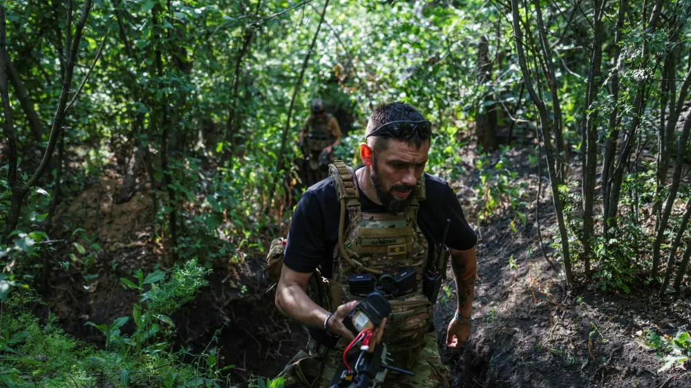 A service member of the 13th Operative Purpose Brigade 'Khartiia' of the National Guard of Ukraine walks at a position with a remote controller near a front line, amid Russia's attack on Ukraine, in Kharkiv region, Ukraine July 20, 2025. REUTERS/Serhii Korovainyi