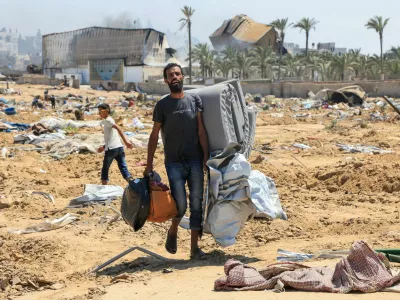 A displaced Palestinian walks in the aftermath of an Israeli military operation in Deir Al-Balah, in the central Gaza Strip, July 22, 2025. REUTERS/Hatem Khaled   TPX IMAGES OF THE DAY