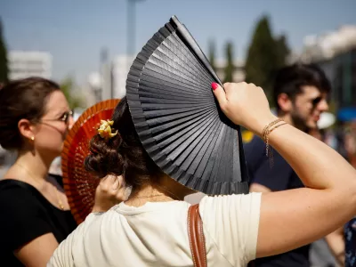 23 July 2025, Greece, Athen: Tourists stand in front of the Greek parliament in the center of Athens. A heatwave with temperatures of over 40 degrees is making life difficult for people in large parts of Greece. Photo: Socrates Baltagiannis/dpa