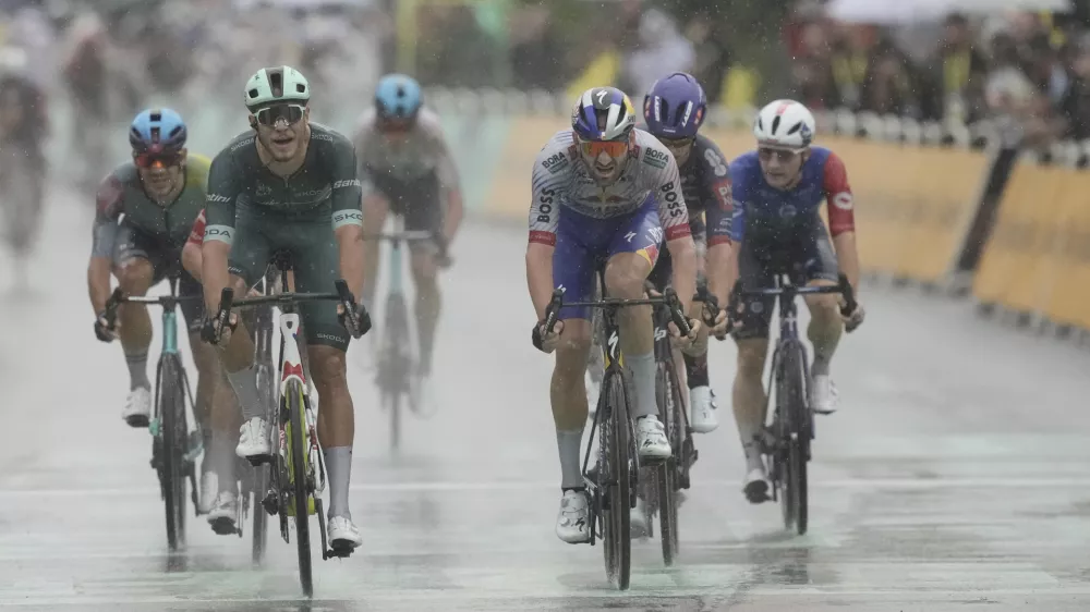 Italy's Jonathan Milan, second left, crosses the finish line ahead of Belgium's Jordi Meeus to win the seventeenth stage of the Tour de France cycling race over 160.4 kilometers (99.7 miles) with start in Bollene and finish in Valence, France, Wednesday, July 23, 2025. (AP Photo/Thibault Camus)