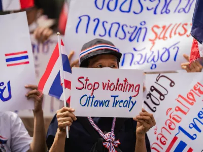 Bangkok, 20 July 2025 – A protester holds a sign reading "Stop violating Ottawa Treaty" during a nationalist demonstration outside the Cambodian Embassy in Bangkok. Protesters gathered outside the Royal Embassy of Cambodia to denounce Cambodia's alleged use of landmines on Thai territory, following the injury of Thai soldiers near the Chong Bok border area. Authorities claim the mines, recently discovered beyond Cambodia's military line, violate the Ottawa Convention.Bangkok, 20 juillet 2025 – Une manifestante brandit une pancarte « Stop violating Ottawa Treaty » lors d'un rassemblement nationaliste devant l'ambassade du Cambodge a Bangkok. Des manifestants se sont rassembles devant l'Ambassade Royale du Cambodge pour denoncer l'usage presume de mines antipersonnel par le Cambodge sur le territoire thailandais, apres la blessure de soldats thailandais pres de la frontiere de Chong Bok. Les autorites affirment que les mines, recemment decouvertes au-dela de la ligne militaire cambodgienne, enfreignent la Convention d'Ottawa.