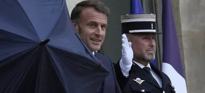French President Emmanuel Macron uses an umbrella as he waits for Lebanese Prime Minister Nawaf Salam Thursday, July 24, 2025 at the Elysee Palace in Paris. (AP Photo/Michel Euler)