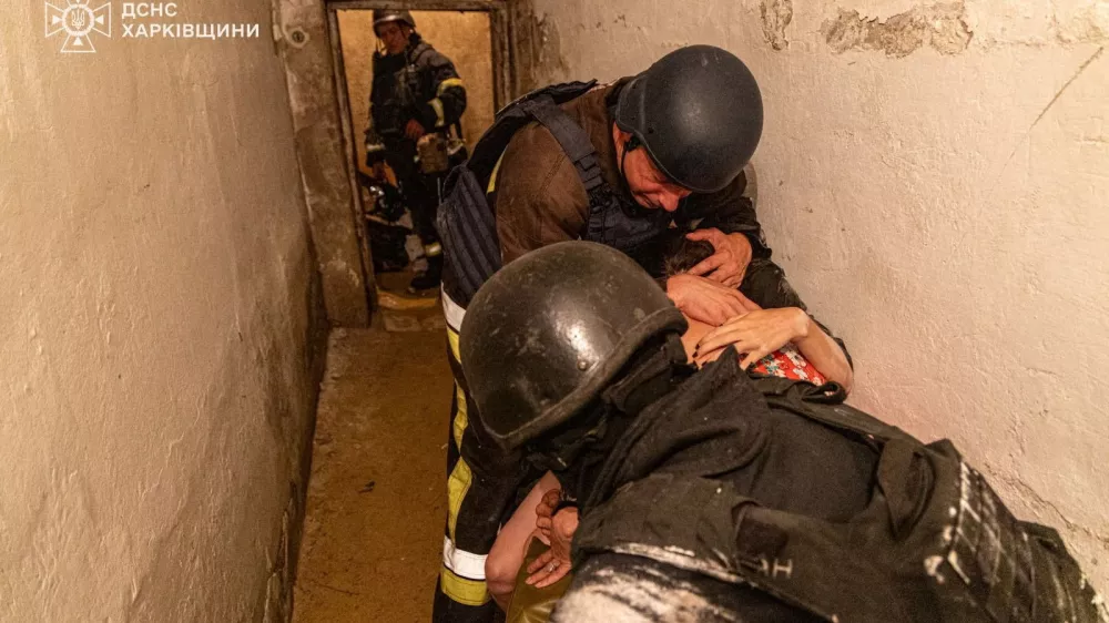 Rescuers protect with their bodies residents as they take shelter inside a basement of a residential building during the Russian drone strike, amid Russia's attack on Ukraine, in Kharkiv, Ukraine in this handout picture released on July 26, 2025. Press service of the State Emergency Service of Ukraine in Kharkiv region/Handout via REUTERS ATTENTION EDITORS - THIS IMAGE HAS BEEN SUPPLIED BY A THIRD PARTY. MUST NOT OBSCURE LOGO.