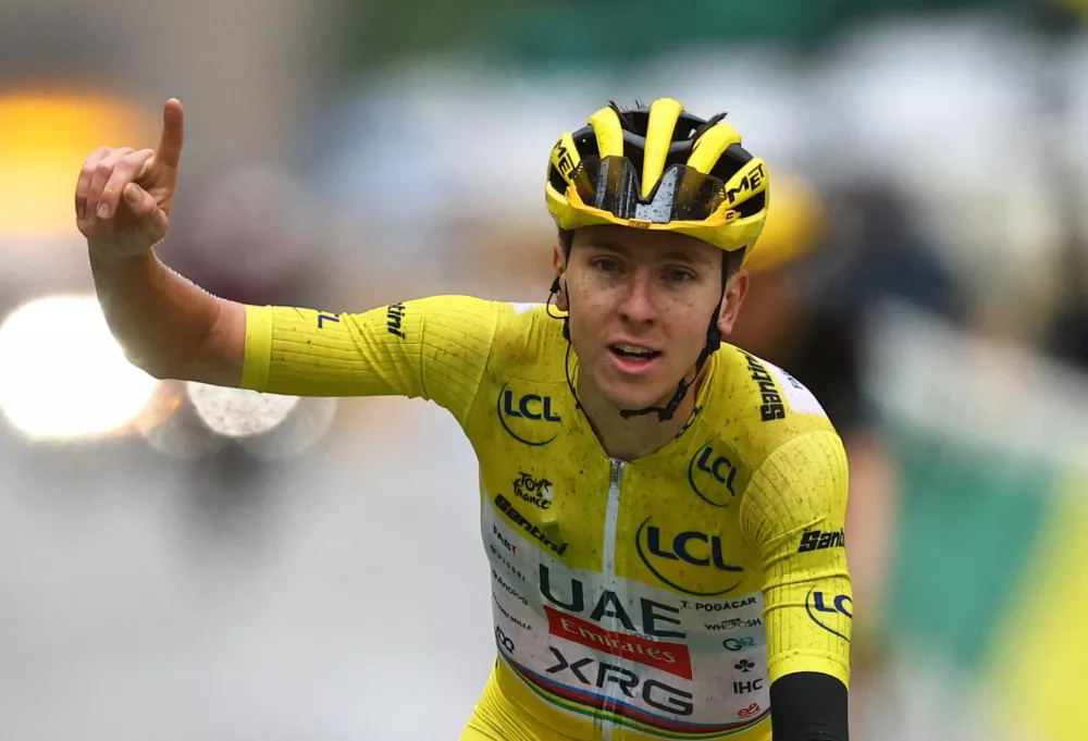 Cycling - Tour de France - Stage 21 - Mantes-la-Ville to Paris - Paris, France - July 27, 2025 UAE Team Emirates XRG's Tadej Pogacar celebrates as he crosses the finish line while wearing the yellow jersey after stage 21 to win the Tour de France REUTERS/Sarah Meyssonnier