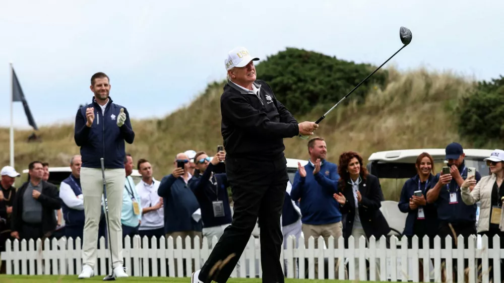 Eric Trump applauds as his father, U.S. President Donald Trump, tees off, on the day of the grand opening of Trump International Golf Links Aberdeen in Balmedie, Aberdeen, Scotland, Britain, July 29, 2025. REUTERS/Evelyn Hockstein