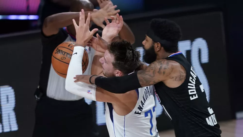 ﻿Dallas Mavericks' Luka Doncic (77) is fouled by Los Angeles Clippers' Marcus Morris Sr. during the first half of an NBA first round playoff game Sunday, Aug. 30, 2020, in Lake Buena Vista, Fla. (AP Photo/Ashley Landis)