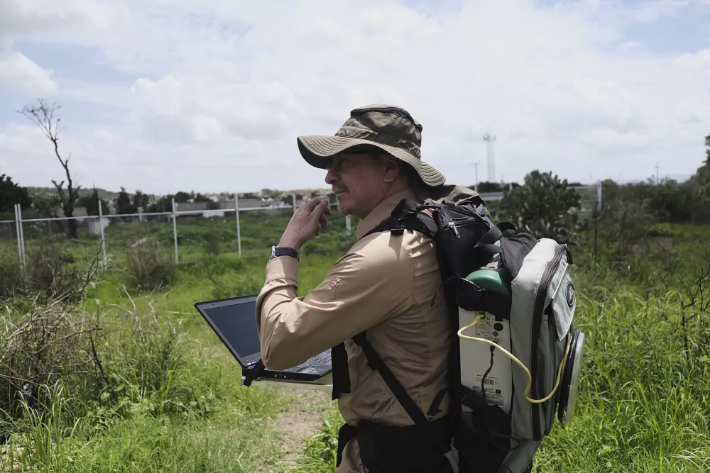 Jose Luis Silvan, researcher and coordinator of the project conducting experiments to improve the location of clandestine graves through observation, geological analysis, and geospatial drones, reviews the location of graves containing pig carcasses in Zapopan, Mexico, Thursday, July 10, 2025. (AP Photo/Alejandra Leyva)