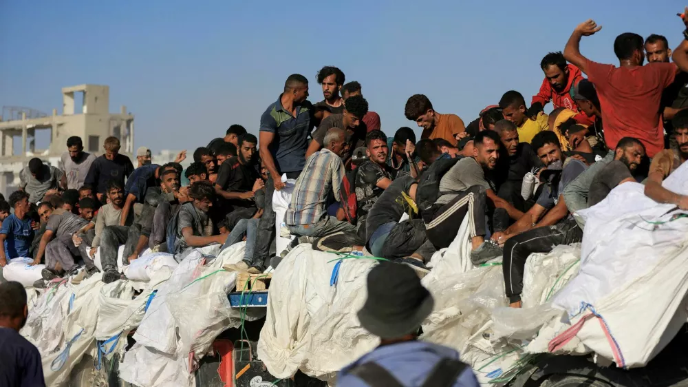 Palestinians sit on aid supplies that entered Gaza through Israel, in Beit Lahia in the northern Gaza Strip, July 30, 2025. REUTERS/Dawoud Abu Alkas   TPX IMAGES OF THE DAY