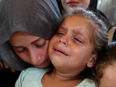 A woman and a child react during the funeral of Palestinians, who were killed by Israeli fire while trying to receive aid on Wednesday, and Palestinians who were killed in overnight Israeli airstrikes on tents, according to medics, at Nasser Hospital in Khan Younis, southern Gaza Strip, July 31, 2025. REUTERS/Ramadan Abed   TPX IMAGES OF THE DAY