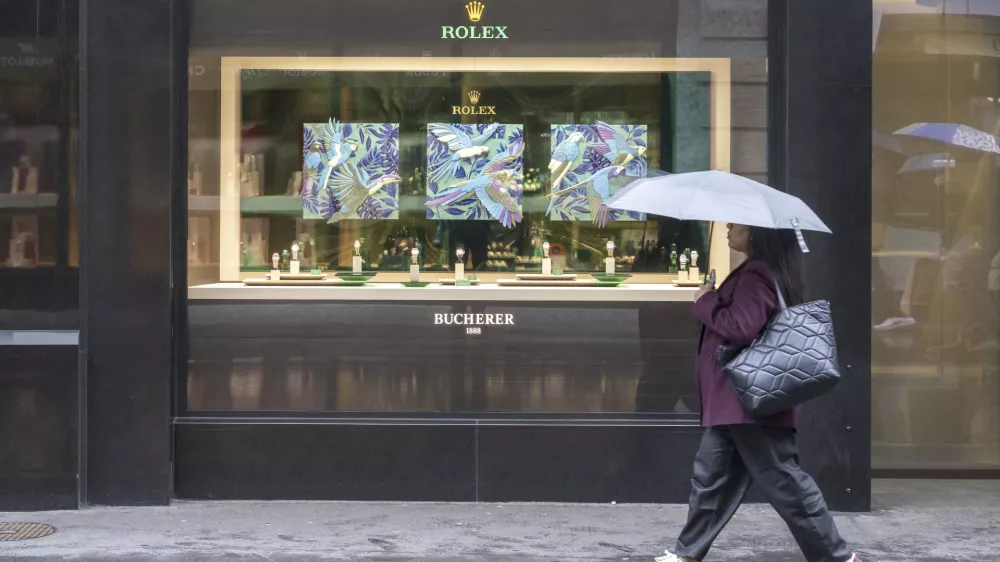A woman walks by a store selling Rolex watches, on Grendelstrasse, Wednesday, April 16, 2025 in Lucerne, Switzerland. (Urs Flueeler/Keystone via AP)