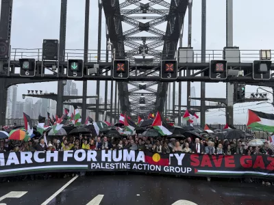 Thousands of protesters walk across the Sydney Harbour Bridge during the Palestine Action Group's March for Humanity in Sydney, Sunday, Aug. 3, 2025. (Dean Lewins/AAP Image via AP)