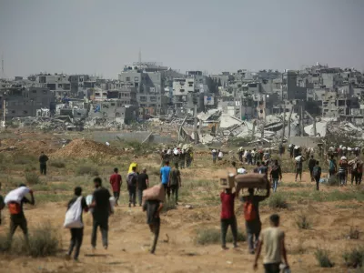 Palestinians carry aid supplies which they received from the U.S.-backed Gaza Humanitarian Foundation (GHF), in the central Gaza Strip, August 4, 2025. REUTERS/Stringer