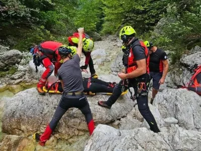 Gorski reševalci iz Bovca pomagajo ponesrečenki pri raftingu. 
