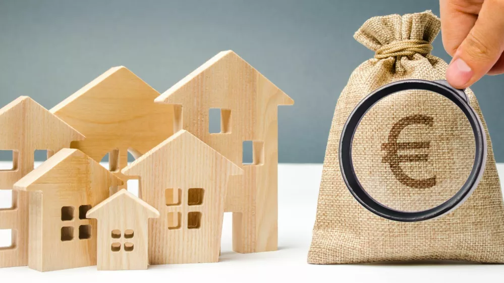 ﻿Bag with money and euro sign and wooden houses. Financing in the country. Investing money in real estate. Saving and accumulation of money. Mortgage. Buying a home. Property sale. City budget.