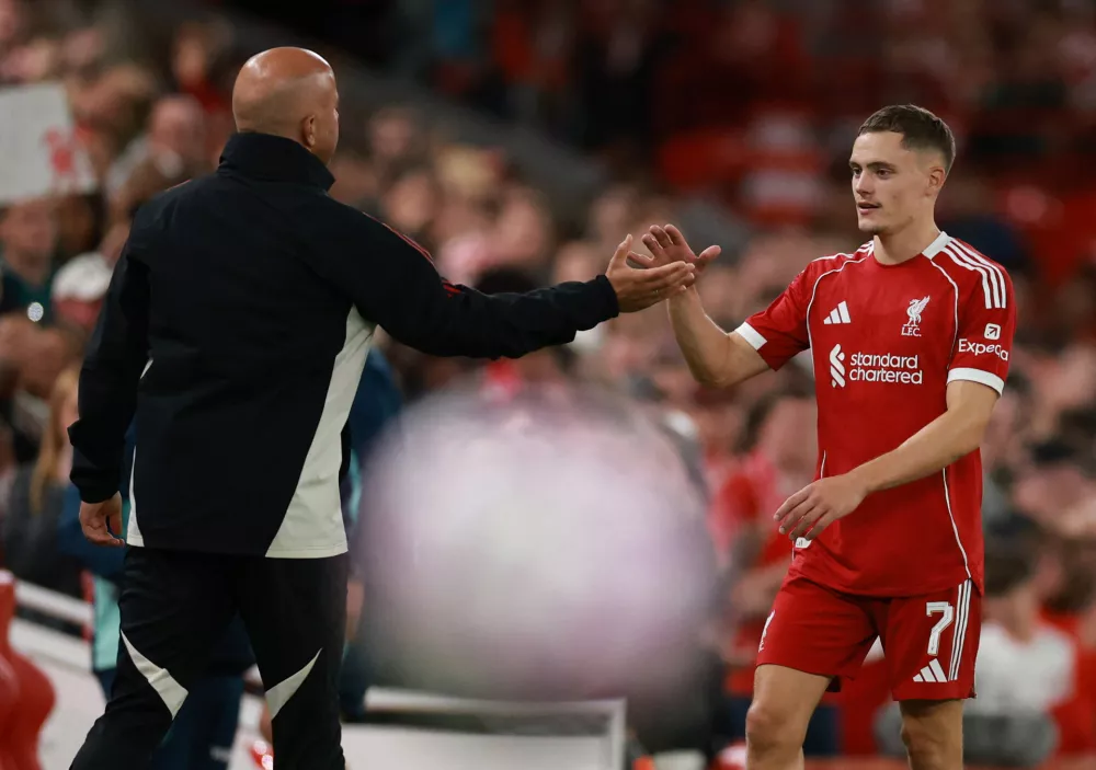 Soccer Football - Friendly - Liverpool v Athletic Bilbao - Anfield, Liverpool, Britain - August 4, 2025 Liverpool's Florian Wirtz shakes hands with manager Arne Slot after being substituted REUTERS/Phil Noble