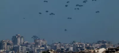 Humanitarian aid packages are airdropped over the Gaza Strip, as seen from Israel, August 5, 2025. REUTERS/Amir Cohen   TPX IMAGES OF THE DAY
