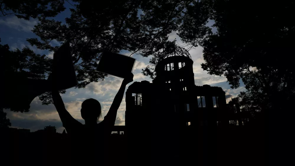 A Pro-Palestinian protester is silhouetted in front of the dome, a day ahead of the 80th anniversary of the World War Two atomic bombing in Hiroshima, western Japan, August 5, 2025. REUTERS/Kim Kyung-Hoon  TPX IMAGES OF THE DAY / Foto: Kim Kyung-hoon