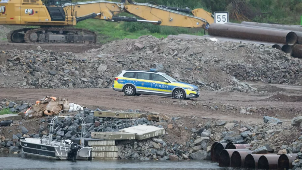 05 August 2025, Saxony, Dresden: A police vehicle stands on the construction site at the demolished Carola Bridge on the Neustadt side of the Elbe. Another bomb from the Second World War has been found during clearance work on the former Elbe crossing. Photo: Sebastian Kahnert/dpa