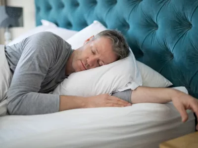 Man sleeping on bed in bedroom at home