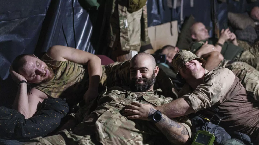 Ukrainian servicemen of the 148th artillery brigade rest in a dugout at the frontline in Zaporizhzhia region, Ukraine, on Thursday, Aug. 7, 2025. (AP Photo/Evgeniy Maloletka)