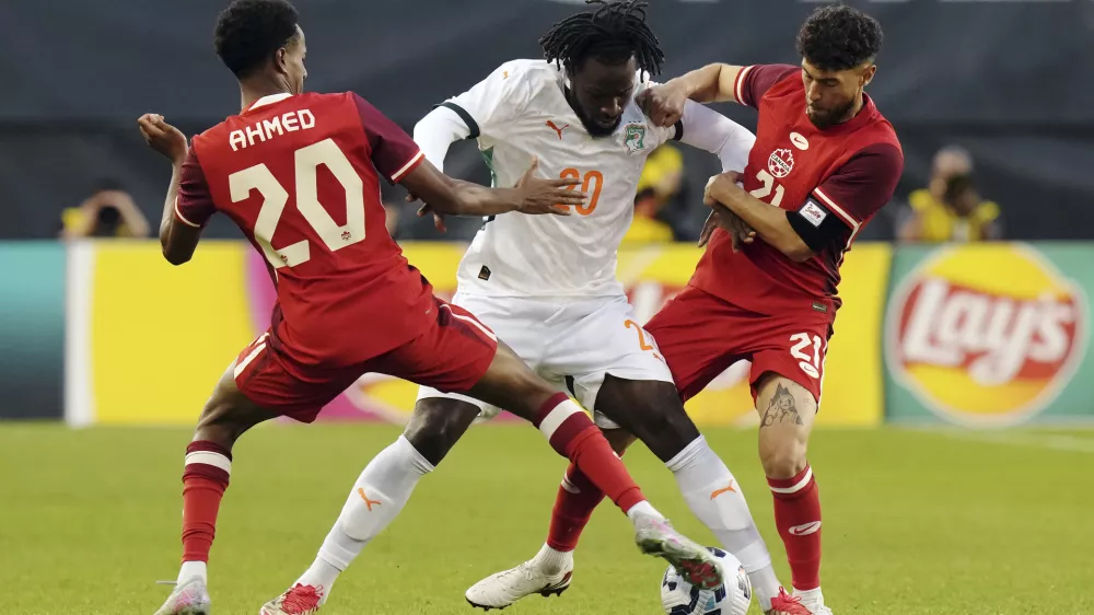 FILE - Canada's Ali Ahmed, left, and Jonathan Osorio, right, battle with Ivory Coast's Evann Guessand during first half Canadian Shield Tournament action, in Toronto, on Tuesday June 10, 2025. (Chris Young/The Canadian Press via AP, file)