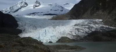 FILE - A canoe, bottom right, glides on Mendenhall Lake, in front of the Mendenhall Glacier, on Sunday, May 18, 2025, in Juneau, Alaska. (AP Photo/Becky Bohrer, File)