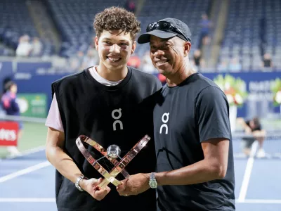 Ben Shelton, left, of the United States, poses with his father Bryan Shelton, right, as they hold the trophy after Ben defeated Karen Khachanov, of Russia, to win the men's final at the National Bank Open tennis tournament in Toronto, Thursday, Aug. 7, 2025. (Chris Young/The Canadian Press via AP)