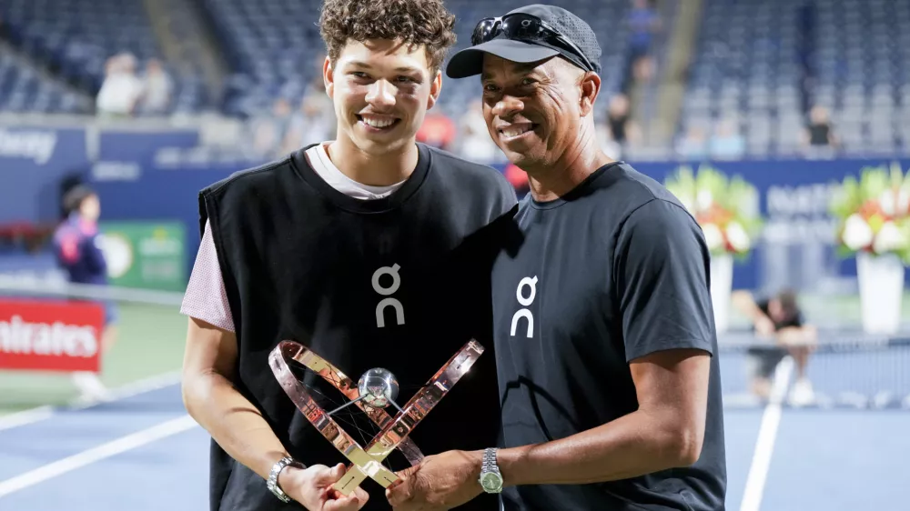 Ben Shelton, left, of the United States, poses with his father Bryan Shelton, right, as they hold the trophy after Ben defeated Karen Khachanov, of Russia, to win the men's final at the National Bank Open tennis tournament in Toronto, Thursday, Aug. 7, 2025. (Chris Young/The Canadian Press via AP)