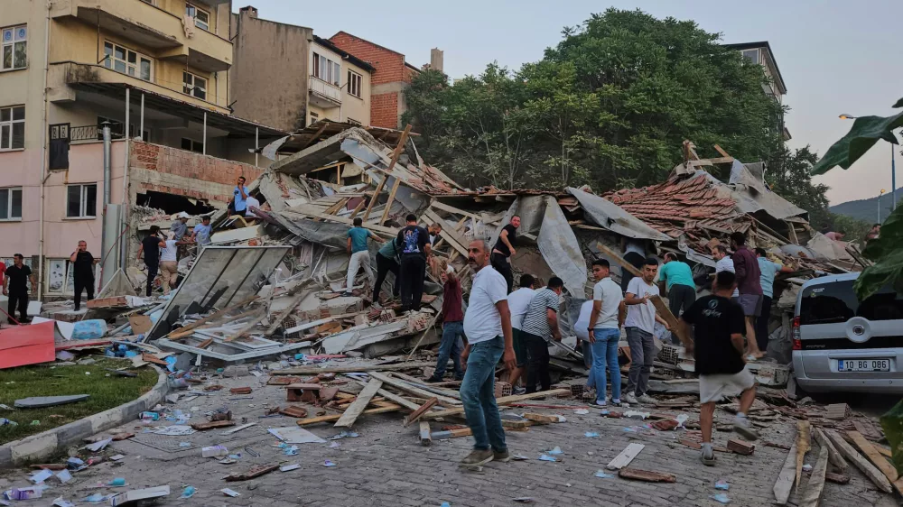 People remove the wreckage of a collapsed building following an earthquake in Sindirgi, northwest Turkey, Sunday, Aug. 10, 2025. (Bahadir Demirceviren/IHA via AP)