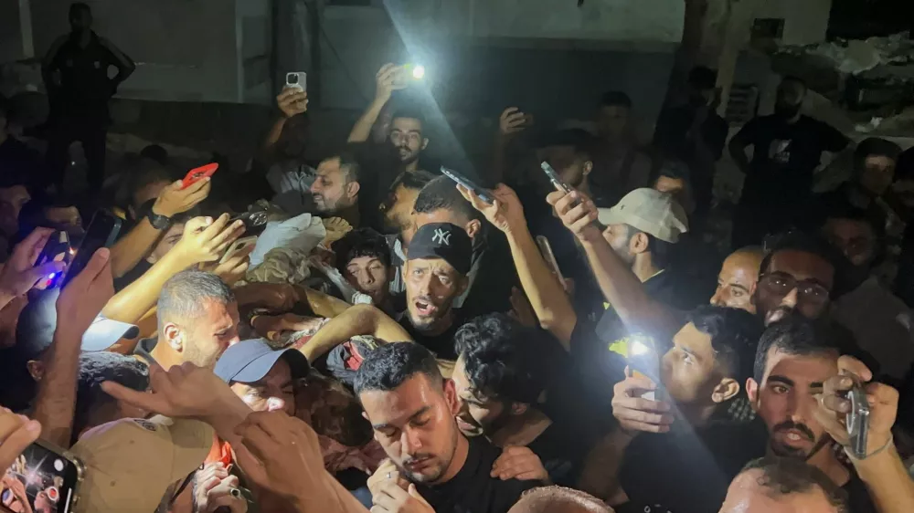 Palestinians hold the body of Al Jazeera journalist Anas Al-Sharif, who Israel's military and Al Jazeera say was killed by an Israeli strike, in Gaza City, August 11, 2025. REUTERS/Ebrahim Hajjaj