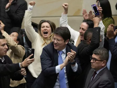 FILE - Miguel Uribe Turbay, center in blue tie, a Colombian senator and presidential candidate for the right-wing Centro Democrático party, celebrates after voting against a labor reform referendum proposed by the government, in Bogota, Colombia, May 14, 2025. (AP Photo/Fernando Vergara, File)