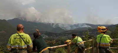 Firefighters wait for orders for deployment while monitoring a wildfire in the area of Voces from a viewpoint in Orellan, Spain, August 11, 2025. REUTERS/Violeta Santos Moura