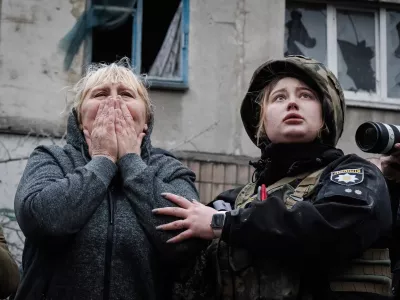 14 April 2023, Ukraine, Sloviansk: A resident reacts next to a policewoman while they await for the rescue team to reach for her family members in the rubble in Sloviansk. Russian troops attacked eastern Ukrainian city Sloviansk on eastern Orthodox great Friday, causing at least 8 dead and 21 injured, including children and many buildings destroyed. Photo: Ashley Chan/SOPA Images via ZUMA Press Wire/dpa