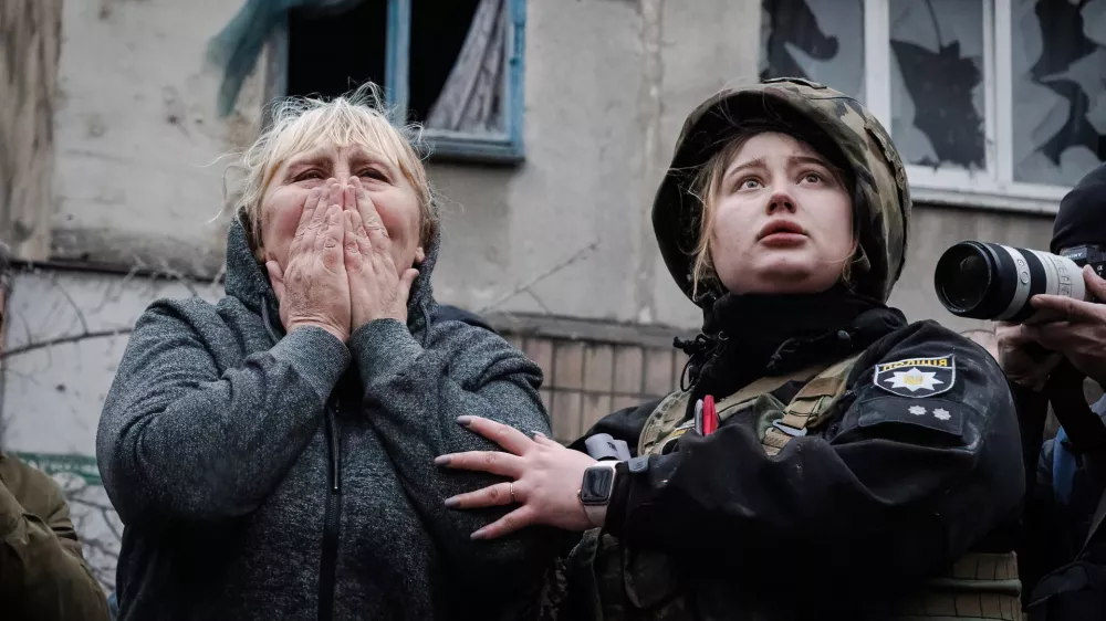14 April 2023, Ukraine, Sloviansk: A resident reacts next to a policewoman while they await for the rescue team to reach for her family members in the rubble in Sloviansk. Russian troops attacked eastern Ukrainian city Sloviansk on eastern Orthodox great Friday, causing at least 8 dead and 21 injured, including children and many buildings destroyed. Photo: Ashley Chan/SOPA Images via ZUMA Press Wire/dpa