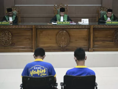Chief Judge Rokhmadi, center, reads his verdict during the sentencing hearing for two men accused of having gay sex, at the Sharia Court in Banda Aceh, Indonesia, Monday, Aug. 11, 2025. (AP Photo/Reza Saifullah)