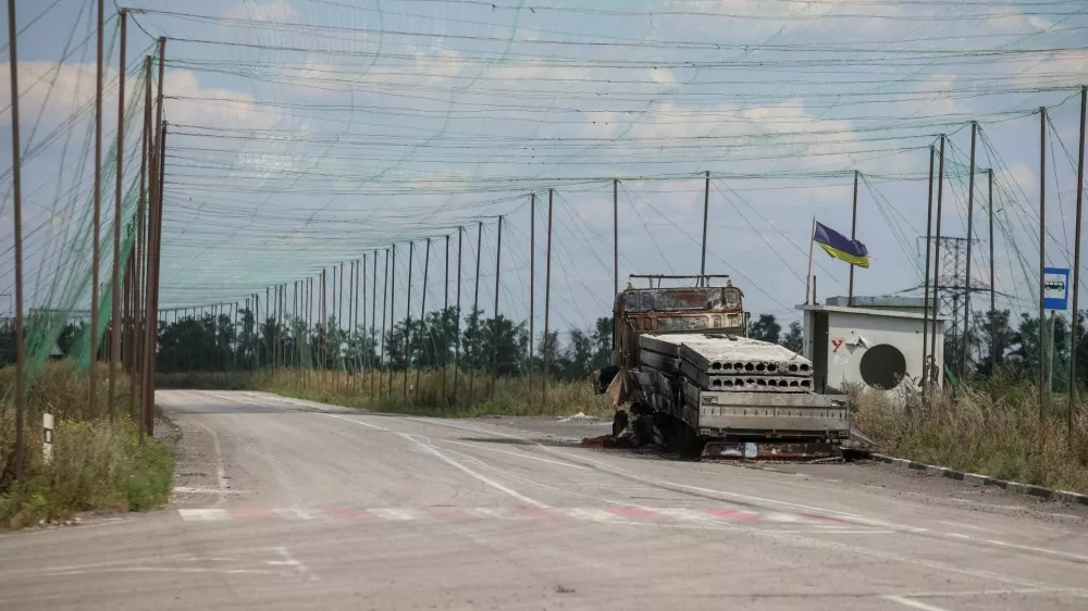 A view shows a burned vehicle and anti-drone nets installed over a road near the frontline town of Dobropillia, amid Russia's attack on Ukraine, in Donetsk region, Ukraine August 10, 2025. REUTERS/Oleksandr Ratushniak