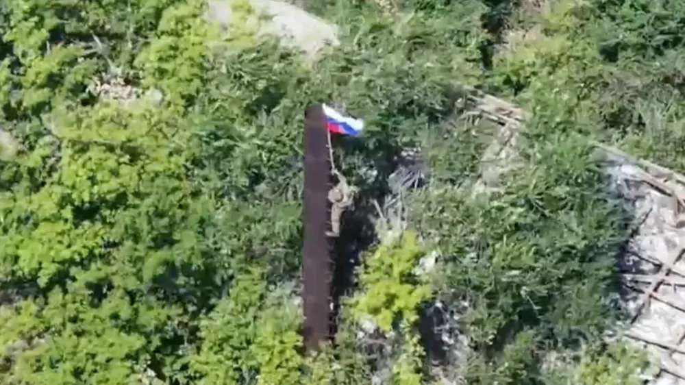 A still image, taken from footage released by the Russian Defence Ministry, shows what it said to be a Russian soldier raising a flag following the capture of Ukraine's Yablunivka (Yablonovka) settlement in the Donetsk region in the course of Russia-Ukraine military conflict, in this image from video released August 12, 2025. Russian Defence Ministry/Handout via REUTERS ATTENTION EDITORS - THIS IMAGE HAS BEEN SUPPLIED BY A THIRD PARTY. NO RESALES. NO ARCHIVES. MANDATORY CREDIT.