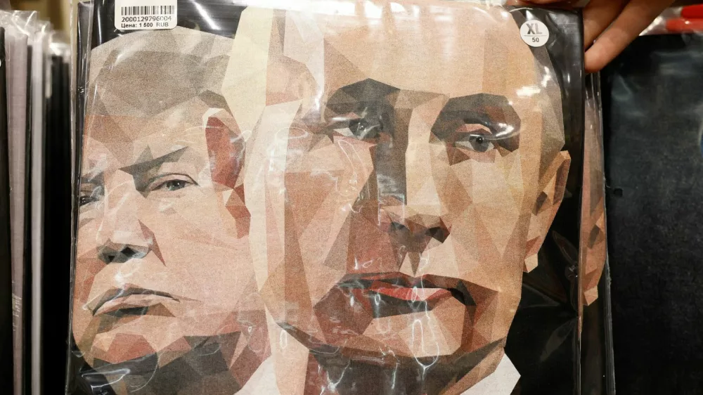 A vendor shows a T-shirt with images of Russian President Vladimir Putin and U.S. President Donald Trump during a demonstration at a gift shop in central Moscow, Russia, August 12, 2025. REUTERS/Yulia Morozova