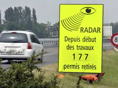FILE - A vehicle passes in front of a sign of the Vaud Cantonal Police indicating the number of driving licences withdrawn for speeding in the construction zone on the A1 motorway between Lausanne and Yverdon, Switzerland, Tuesday, June 15, 2010. (Dominic Favre/Keystone via AP, file)