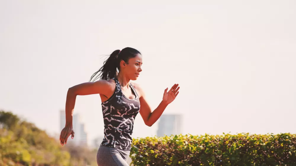 ﻿Sport girl in sporty outfit running at the lane in the park