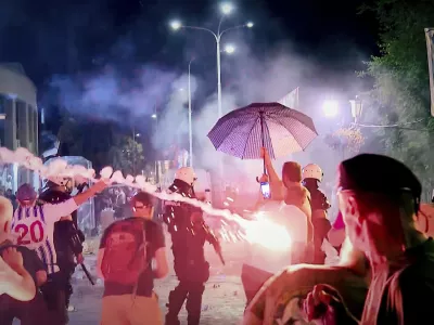An image taken from video shows fireworks flying as clashes erupted at protests in Vrbas, Serbia, Tuesday, Aug. 12, between opponents and supporters of the government in an escalation of tensions following more than nine months of persistent demonstrations against populist President Aleksandar Vucic. (N1 Serbia via AP)