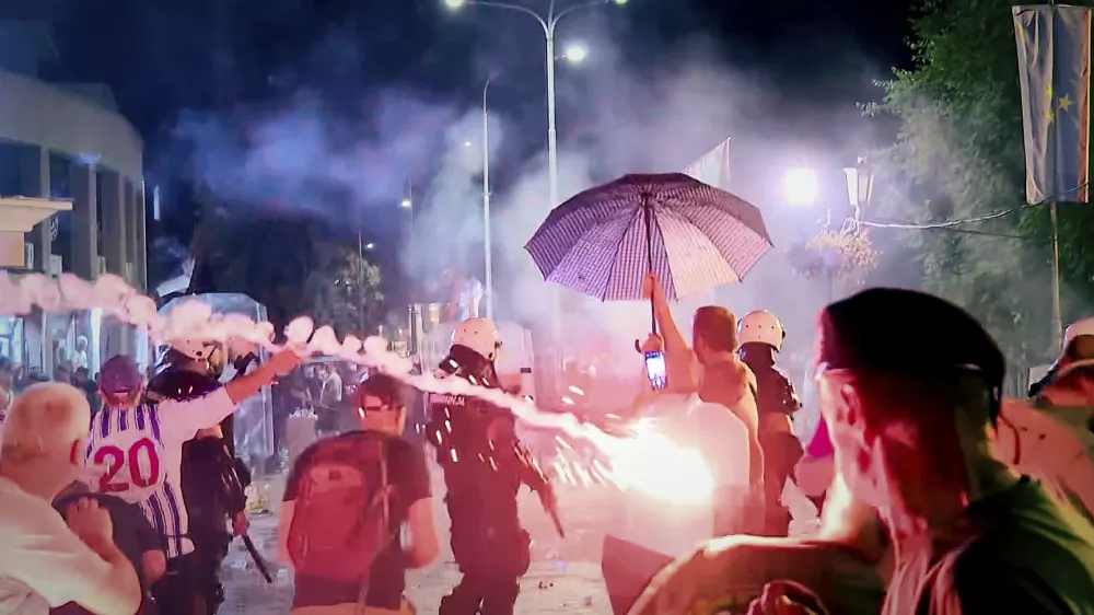 An image taken from video shows fireworks flying as clashes erupted at protests in Vrbas, Serbia, Tuesday, Aug. 12, between opponents and supporters of the government in an escalation of tensions following more than nine months of persistent demonstrations against populist President Aleksandar Vucic. (N1 Serbia via AP)